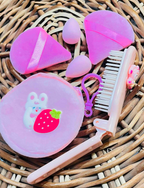 Close-up of foldable comb, plush pouch, puffs and blender sponges
