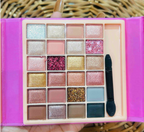 Close up of 24-shade eyeshadow grid with applicator
